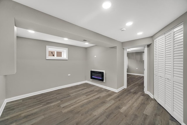 basement with heating unit and dark hardwood / wood-style floors