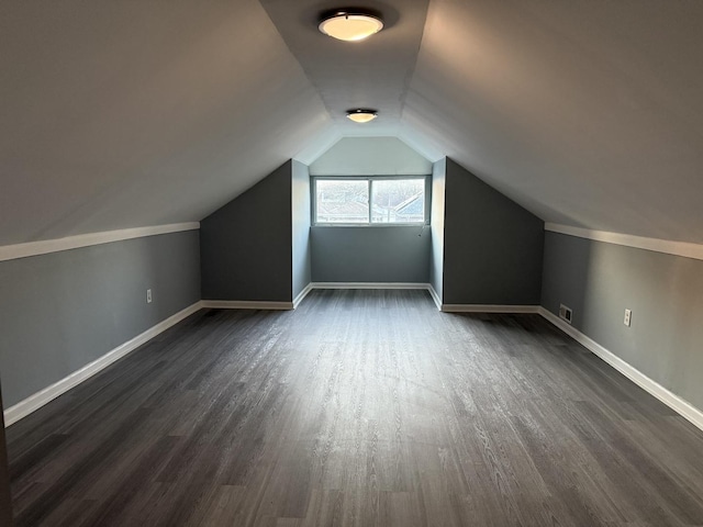 additional living space featuring dark hardwood / wood-style flooring and vaulted ceiling