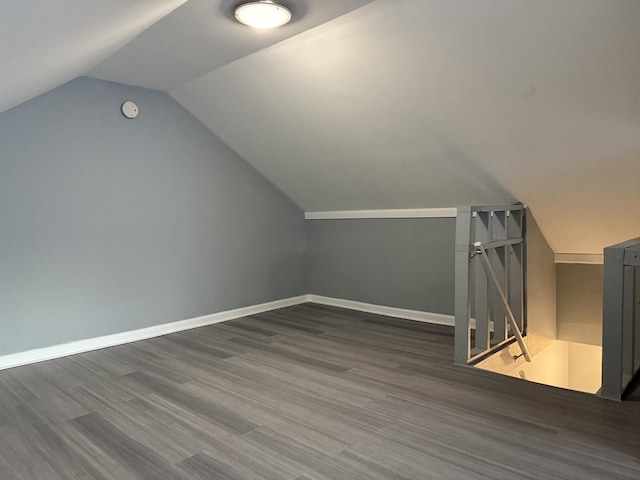 additional living space featuring vaulted ceiling and dark hardwood / wood-style floors