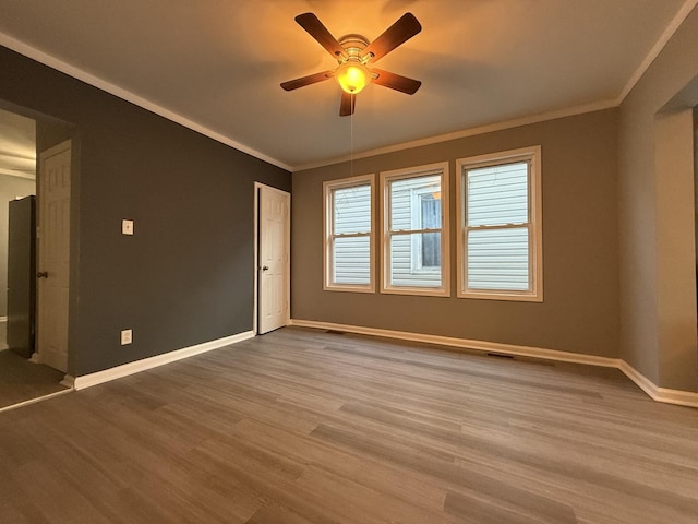 unfurnished room featuring hardwood / wood-style flooring, ornamental molding, and ceiling fan