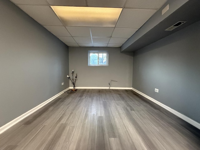 basement featuring a drop ceiling and hardwood / wood-style flooring