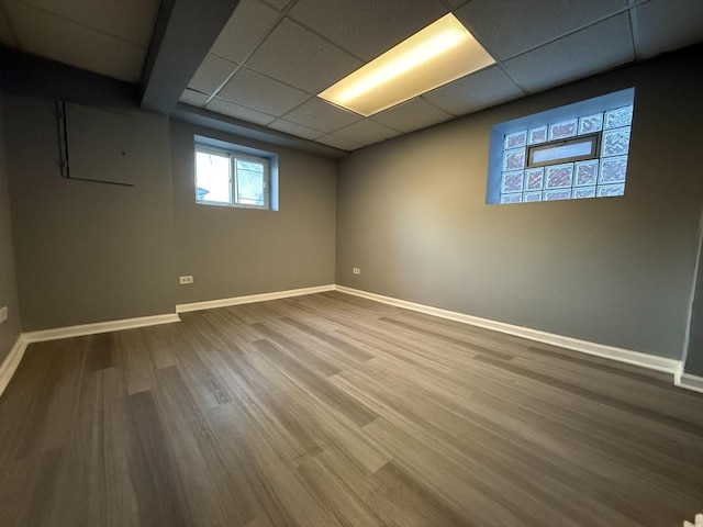 basement with hardwood / wood-style flooring and a paneled ceiling