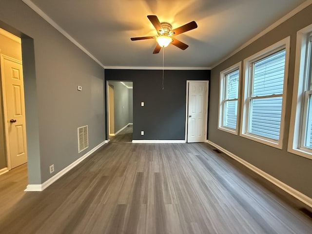 unfurnished room with ornamental molding, dark hardwood / wood-style floors, and ceiling fan