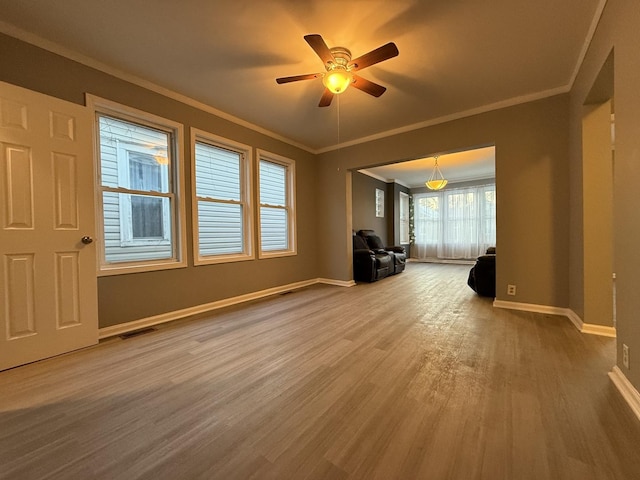 empty room with hardwood / wood-style floors, ornamental molding, and ceiling fan