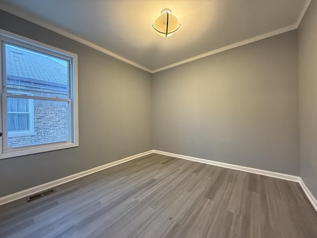 unfurnished room with a healthy amount of sunlight, ornamental molding, and hardwood / wood-style floors