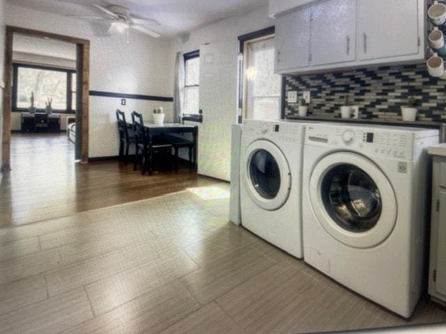 laundry area with cabinets, wood-type flooring, separate washer and dryer, and ceiling fan