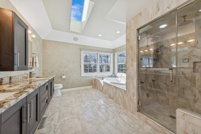 full bathroom featuring shower with separate bathtub, vanity, a skylight, and toilet