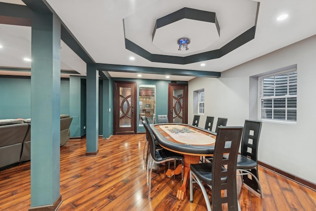 dining room featuring a raised ceiling and wood-type flooring