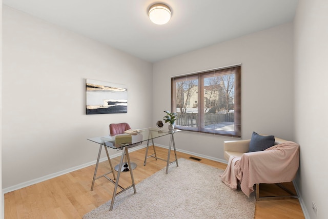 office with wood finished floors, visible vents, and baseboards