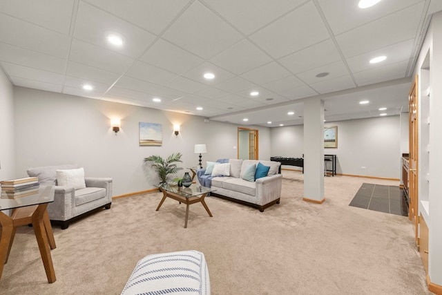 living area featuring recessed lighting, light colored carpet, a drop ceiling, and baseboards