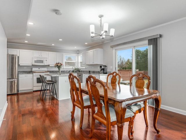 dining room featuring crown molding, dark wood-type flooring, sink, and a chandelier