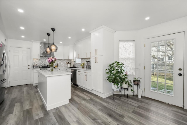 kitchen featuring pendant lighting, sink, white cabinetry, backsplash, and a kitchen island