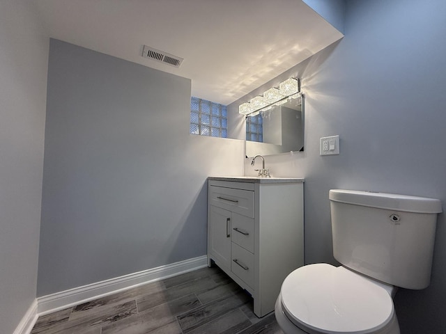 bathroom featuring hardwood / wood-style flooring, vanity, and toilet