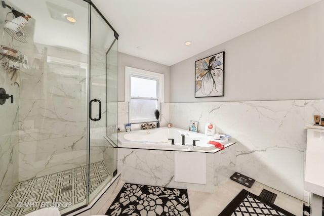 bathroom featuring independent shower and bath and tile walls