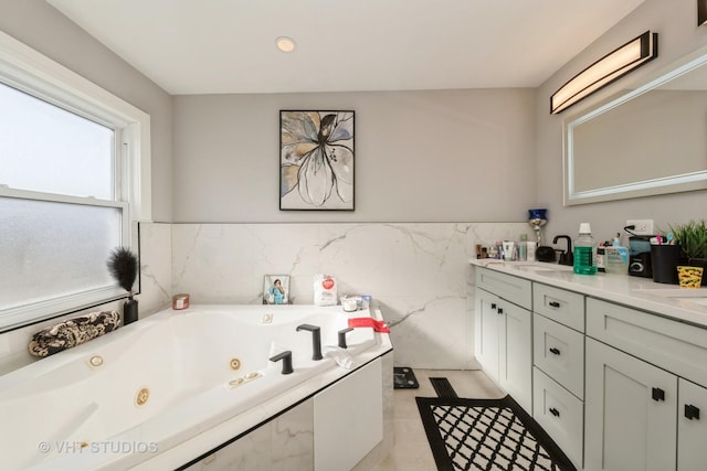 bathroom featuring vanity, a tub to relax in, and tile walls