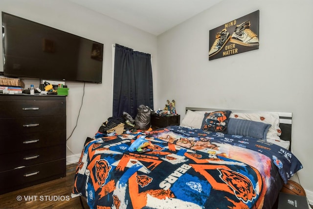 bedroom with dark hardwood / wood-style flooring