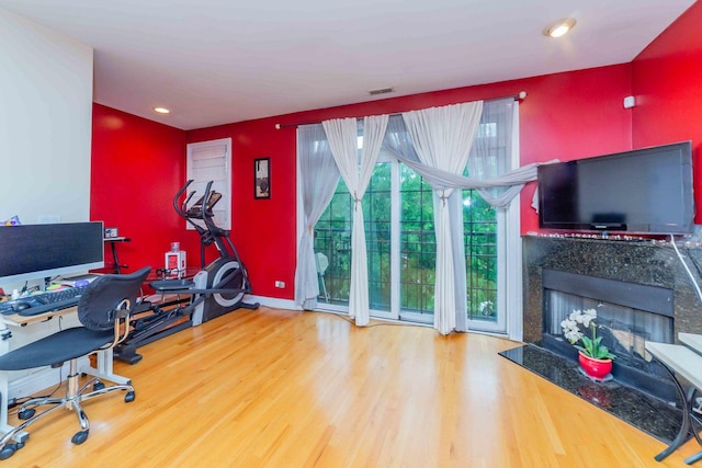 home office featuring hardwood / wood-style floors and a high end fireplace