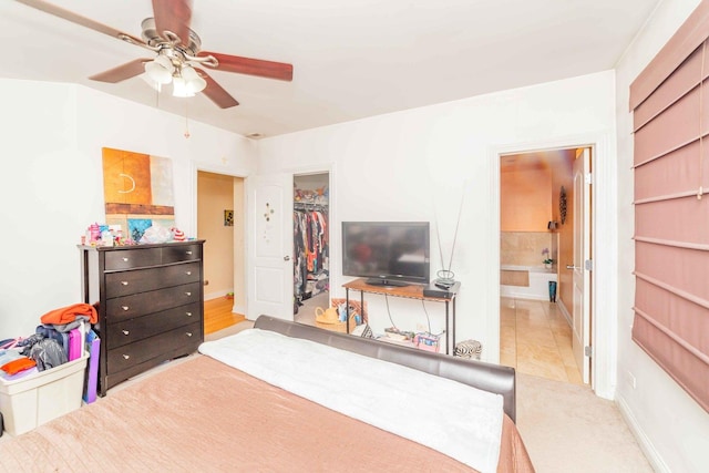 bedroom with a spacious closet, a closet, ceiling fan, and ensuite bathroom