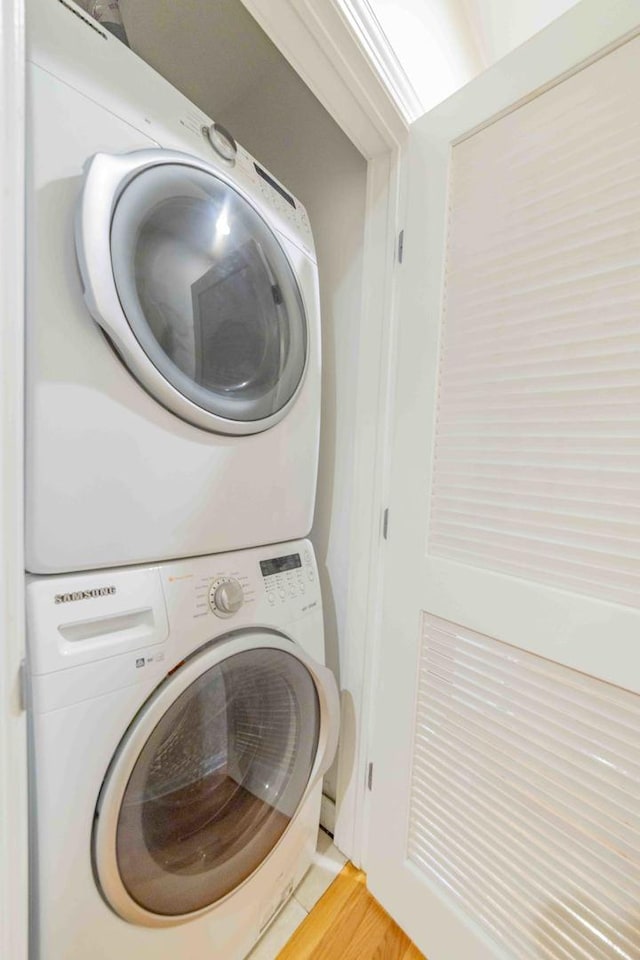 washroom featuring stacked washer and dryer and hardwood / wood-style flooring