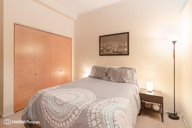 bedroom featuring light carpet and a closet