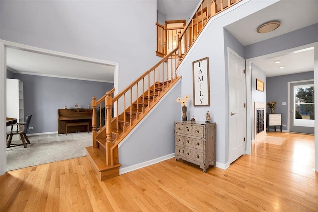 stairway featuring wood-type flooring and a towering ceiling