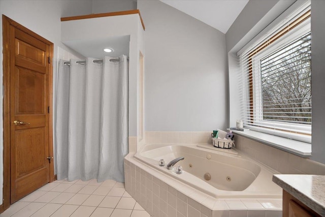 bathroom with a relaxing tiled tub, lofted ceiling, tile patterned floors, and vanity