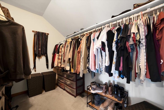 spacious closet with light colored carpet and vaulted ceiling