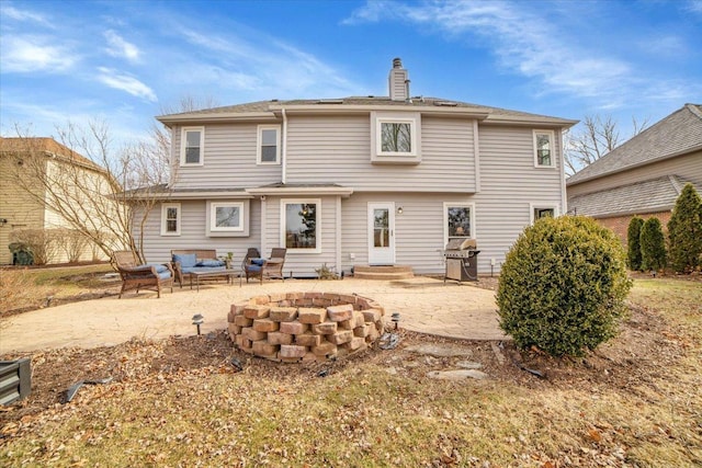 back of property with a patio and an outdoor fire pit