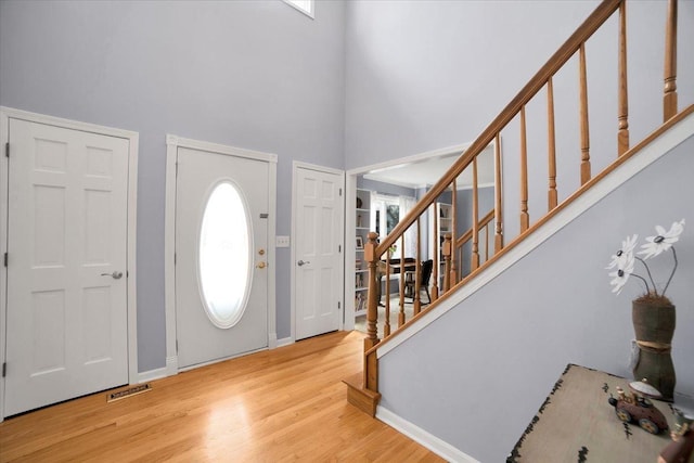 entrance foyer with light hardwood / wood-style floors and a high ceiling