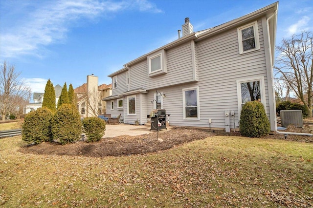 rear view of house with a patio, central AC, and a lawn