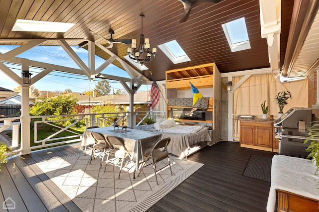 wooden terrace with ceiling fan, exterior kitchen, and area for grilling