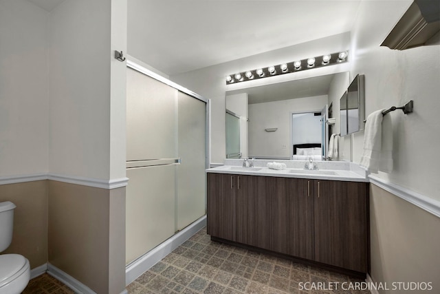 bathroom featuring toilet, vanity, and walk in shower