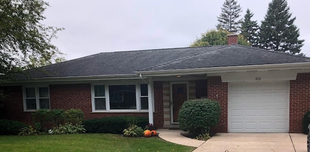 ranch-style house featuring a garage and a front yard