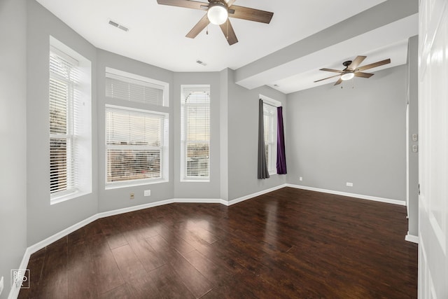 spare room featuring dark wood-type flooring, ceiling fan, and plenty of natural light