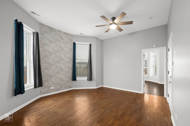 spare room featuring dark wood-type flooring and ceiling fan