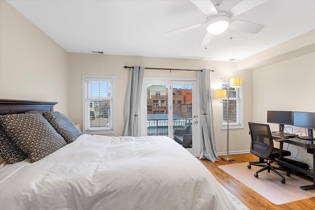 bedroom with light wood-style floors, access to outside, visible vents, and baseboards