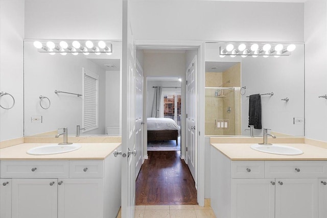 bathroom featuring tile patterned floors, a shower stall, a sink, and ensuite bathroom