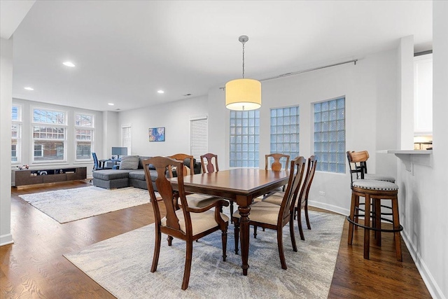 dining space with baseboards, dark wood-type flooring, and recessed lighting