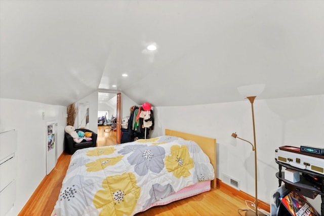 bedroom featuring wood-type flooring and vaulted ceiling