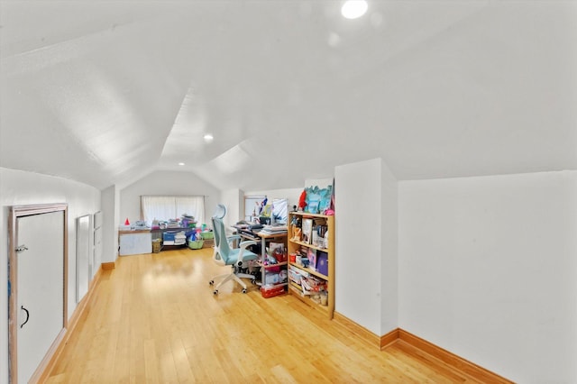 additional living space featuring vaulted ceiling and hardwood / wood-style floors