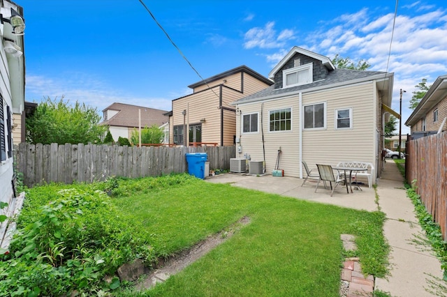 back of property featuring central AC, a patio area, and a lawn