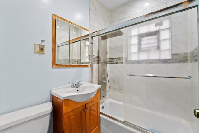 full bathroom with vanity, toilet, and combined bath / shower with glass door