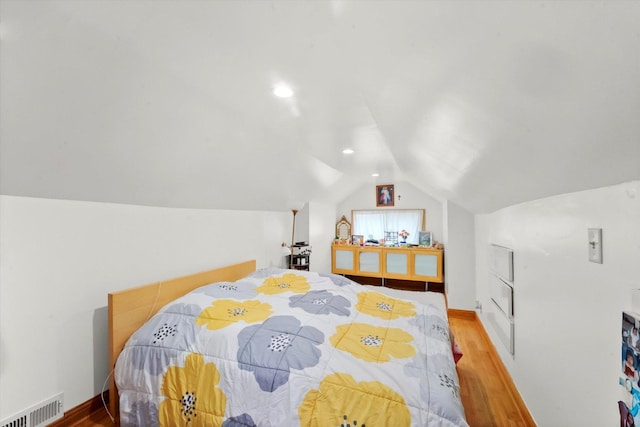 bedroom with lofted ceiling and light hardwood / wood-style floors