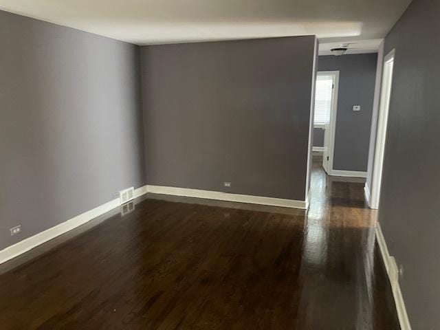 empty room with dark hardwood / wood-style flooring