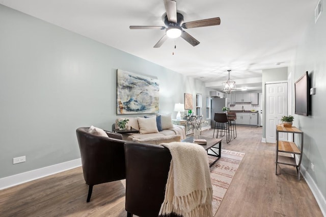 living room featuring wood-type flooring and ceiling fan