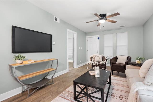 living room with ceiling fan and light wood-type flooring