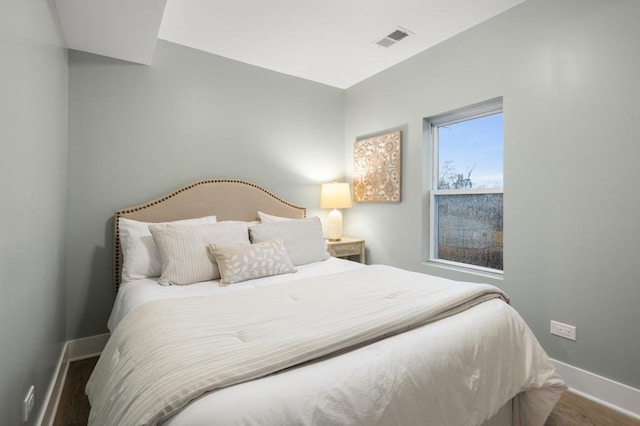 bedroom with dark hardwood / wood-style flooring