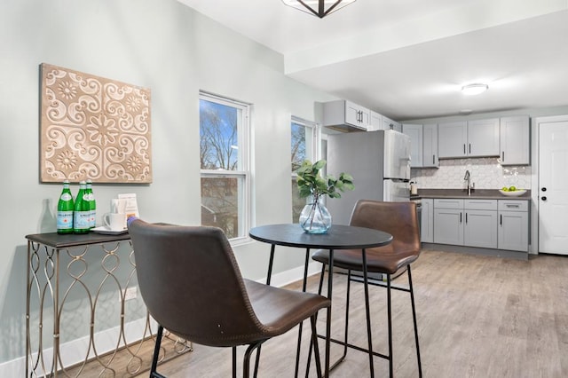 dining area featuring sink and light hardwood / wood-style flooring