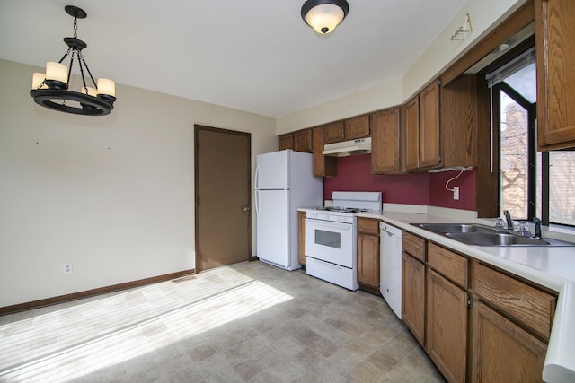 kitchen featuring sink, white appliances, and hanging light fixtures