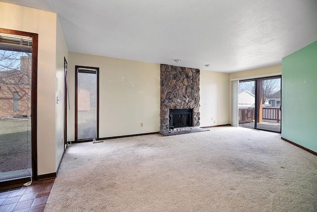 unfurnished living room featuring dark carpet, a textured ceiling, and a fireplace